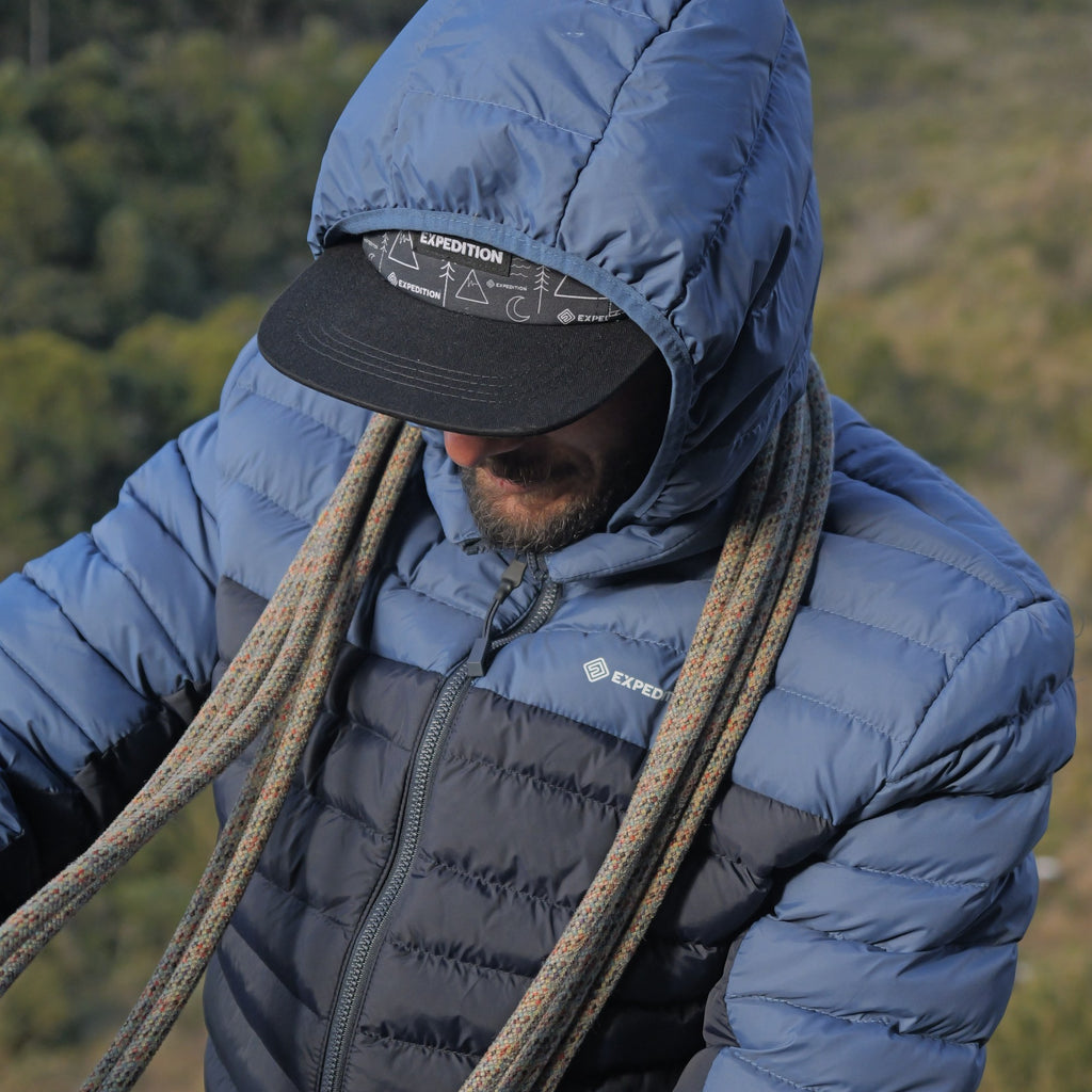 Jaqueta Puff Térmica — detalhe do capuz sobre boné e logo Expedition