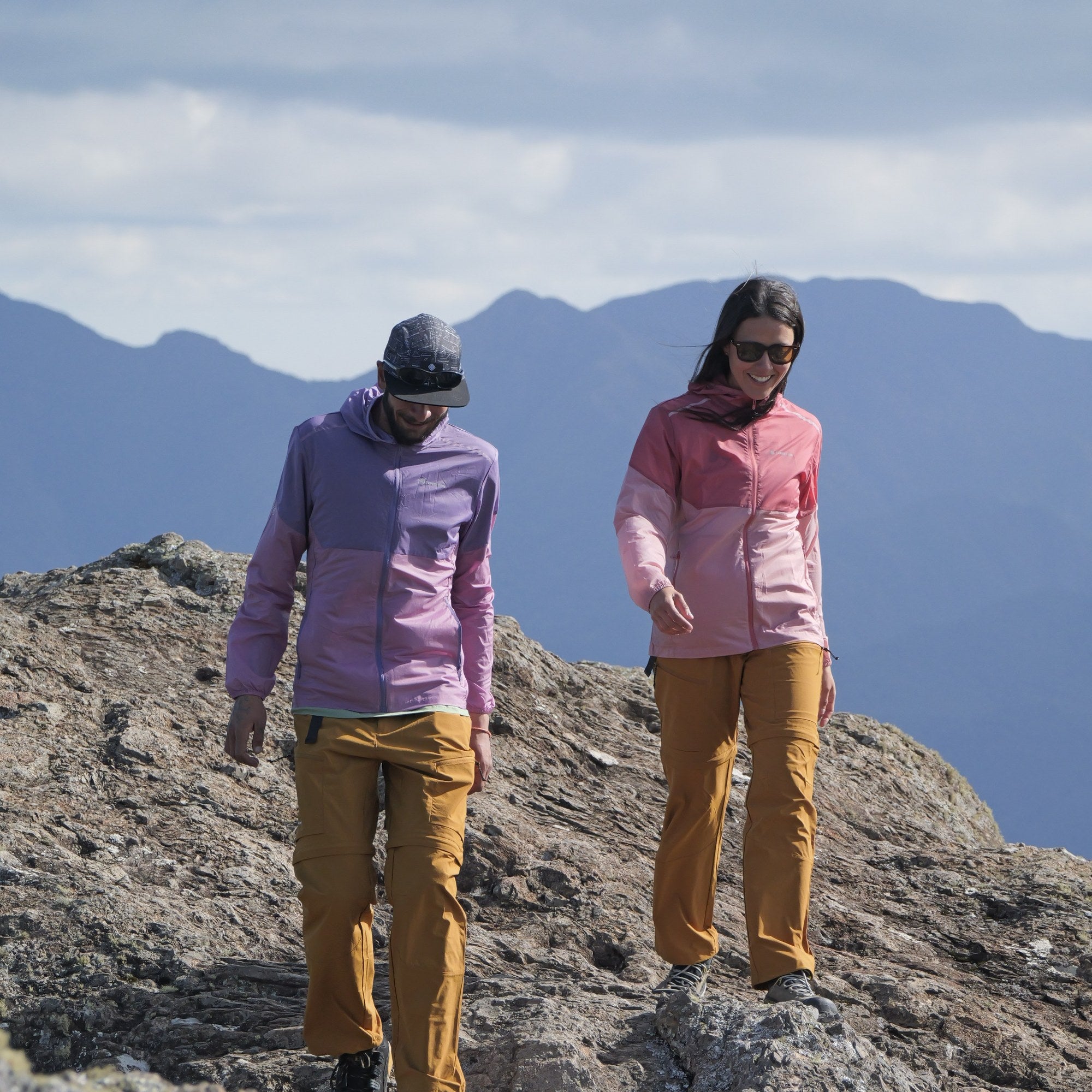 Jaqueta Sollipulli Windshell Feminino — casal caminhando no cume com as windshells rosa e roxa
